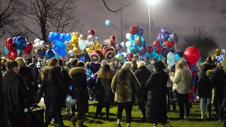 People wait to release balloons in the boys' memory