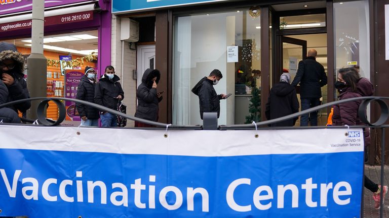 People queue at Melton Road Vaccination Centre in Leicester, as the coronavirus booster vaccination programme is ramped up to an unprecedented pace of delivery, with every eligible adult in England being offered a top-up injection by the end of December. Picture date: Monday December 20, 2021.
