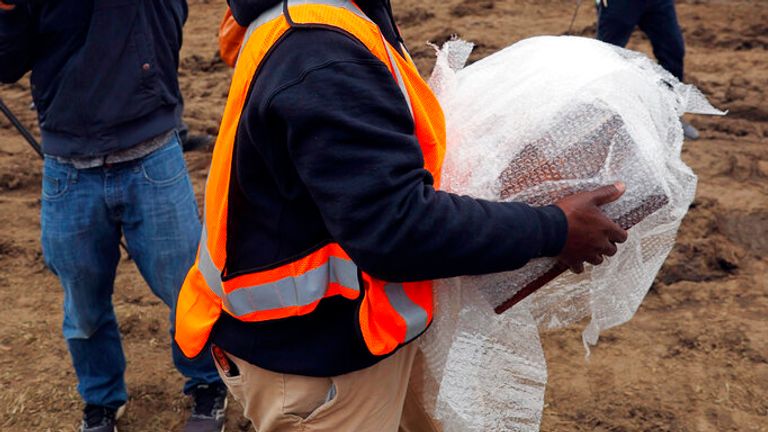 Michael Spence, construction superintendent with Team Henry Enterprises, moves a copper box believed to be the 1887 time capsule that was put under the Robert E. Lee pedestal and recovered on Monday, December 27, 2021.   (Eva Russo/ Richmond Times-Dispatch via AP)