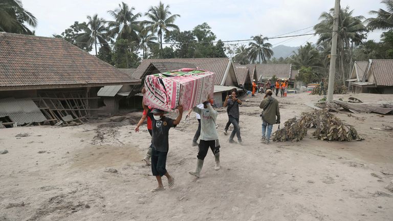 روستاییان در حالی که پس از فوران به مکان امن تری تخلیه می شوند، وسایل خود را حمل می کنند.  عکس: AP