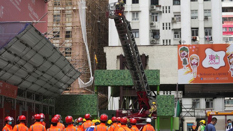 Firefighters operate an extendable ladder to rescue people trapped in a fire that broke out at the World Trade Centre in Hong Kong, China, December 15, 2021. REUTERS/Lam Yik
