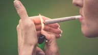 A woman lights a cannabis joint