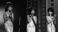 Ronnie Spector (centre) performing with fellow Ronettes Estelle Bennett (L) and Nedra Talley (R) in London in 1965