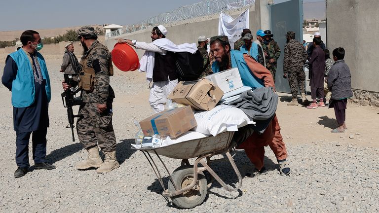 A UN refugee agency worker with aid supplies for displaced Afghan families