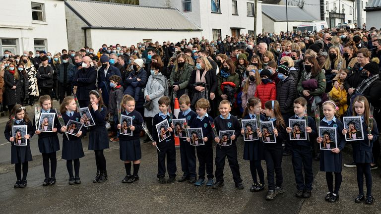 Une garde d'honneur des enfants qu'une enseignante de 23 ans, Ashling Murphy, qui a été assassinée alors qu'elle faisait du jogging, a enseigné à l'école nationale de Durrow tenir ses photos alors que les gens se rassemblent pour ses funérailles près de l'église St Brigid à Mountbolus près de Tullamore, Irlande 18 janvier 2022