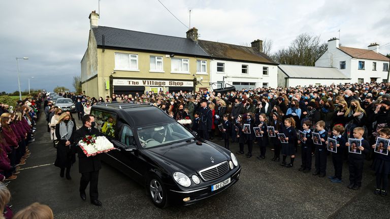 Le corbillard transportant le cercueil de l'enseignante de 23 ans, Ashling Murphy, qui a été assassinée alors qu'elle faisait du jogging, arrive pour ses funérailles en tant que garde d'honneur des enfants qu'elle a enseignés à l'école nationale de Durrow rend hommage par la St Brigid&# 39;s Church à Mountbolus près de Tullamore, Irlande 18 janvier 2022