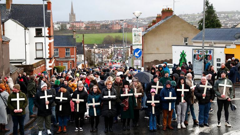 People holding crosses take part in a march to commemorate the victims of Bloody Sunday on the 50th anniversary of the 'Bloody Sunday' shootings in Londonderry, Sunday, Jan. 30, 2022. In 1972 British soldiers shot 28 unarmed civilians at a civil rights march, killing 13 on what is known as Bloody Sunday or the Bogside Massacre. Sunday marks the 50th anniversary of the shootings in the Bogside area of Londonderry .(AP Photo/Peter Morrison)