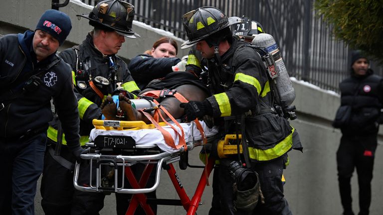 Emergency personnel from the FDNY provide medical aid as they respond to an apartment building fire in the Bronx borough of New York City, U.S., January 9, 2022. REUTERS/Lloyd Mitchell