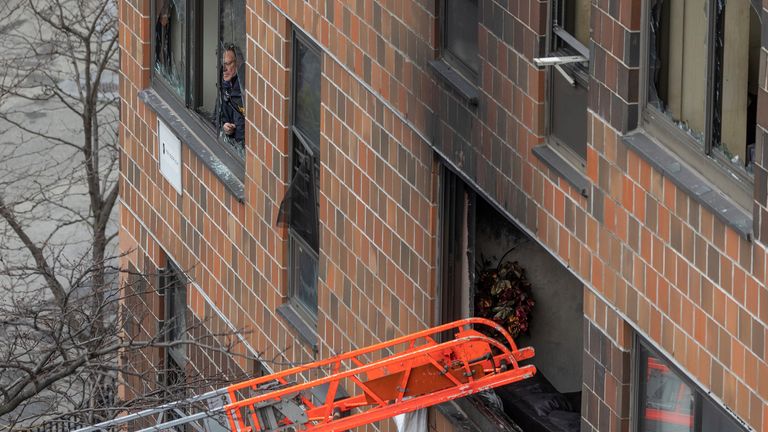 A ladder leads up to a window after a fatal fire at an apartment building in the Bronx on Sunday, Jan. 9, 2022, in New York. The majority of victims were suffering from severe smoke inhalation, FDNY Commissioner Daniel Nigro said. (AP Photo/Yuki Iwamura) 