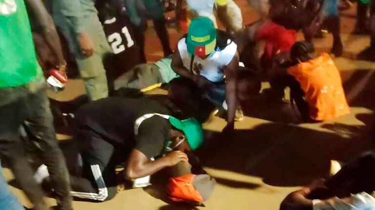 People assist victims of a stampede outside a stadium hosting an African Cup of Nations soccer game in Yaounde, Cameroon, Monday Jan. 24, 2022. Several people have died in a stampede that happened as crowds struggled to get access to Olembe Stadium to watch the host country play Comoros in a last 16 knockout game in Africa&#39;s top soccer tournament. (AP Photo/Thierry Noukeu)


