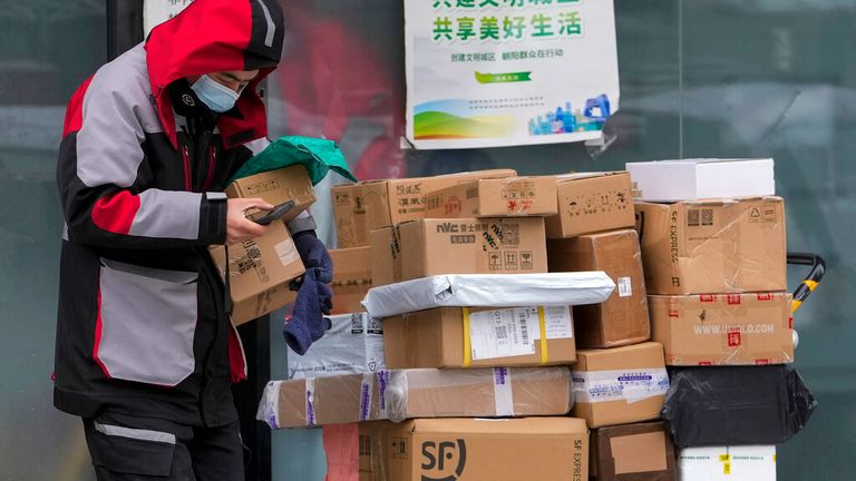 A private delivery company&#39;s worker wearing a face mask picks up parcels at a distribution center in Beijing, Sunday, Nov. 7, 2021. China&#39;s exports remained strong in October, a positive sign for an economy trying to weather power shortages and COVID-19 outbreaks. (AP Photo/Andy Wong)