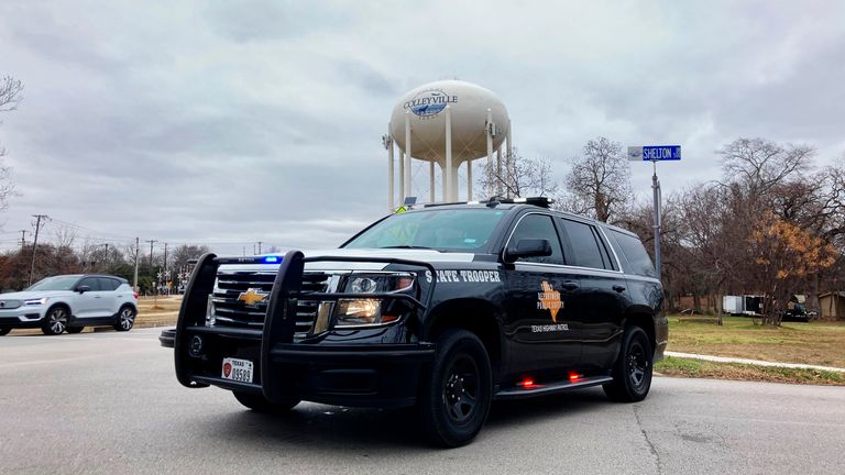 A Texas state trooper blocks traffic on a road leading to a Colleyville, Texas synagogue where a man apparently took hostages Saturday, Jan. 15, 2022. (AP Photo/Jake Bleiberg)