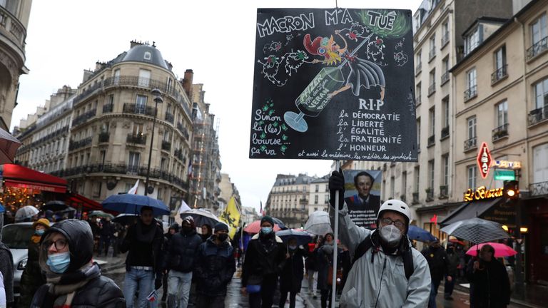 A protester holds a placard that reads "Macron killed me"&#39; during a rally. Pic: AP