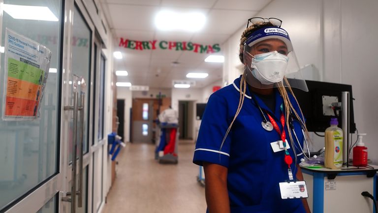 Un membre du personnel traverse une salle pour patients Covid au King's College Hospital, dans le sud-est de Londres.  Photo date : mardi 21 décembre 2021