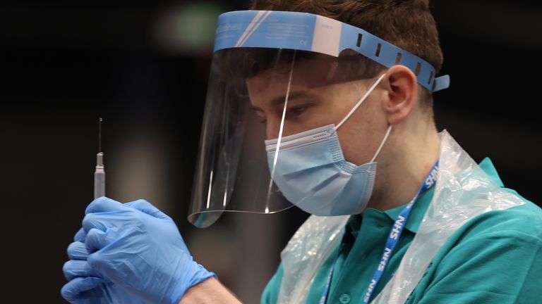 A vaccinator prepares vaccines at a COVID-19 booster vaccination centre at the Titanic Exhibition Centre in Belfast