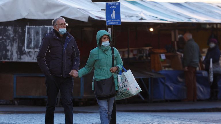 A woman and man wearing face masks shop in Cambridge Market Square, amid the coronavirus disease (COVID-19) outbreak, in Cambridge, Britain, January 14, 2022. REUTERS/Andrew Couldridge
