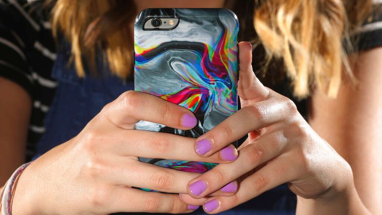 Rachel Whalen looks at her phone at her home in Draper, Utah. Whalen remembers feeling gutted in high school when a former friend would mock her online postings, threaten to unfollow or unfriend her on social media and post inside jokes about her to others online. (AP/Rick Bowmer)