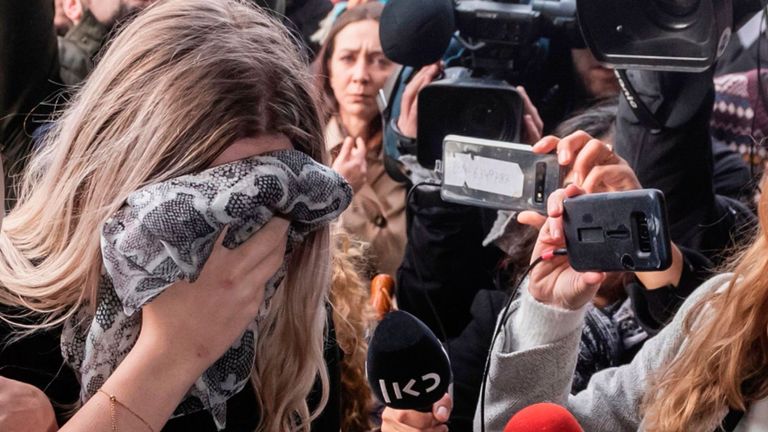 The woman is pictured covering her face outside the Cypriot Supreme Court in Nicosia in 2022
