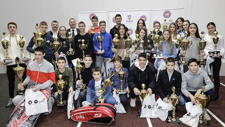 جوکوویچ با کاپوت مشکی در وسط پشت عکس دسته جمعی دیده می شود.  عکس: انجمن تنیس صربستان