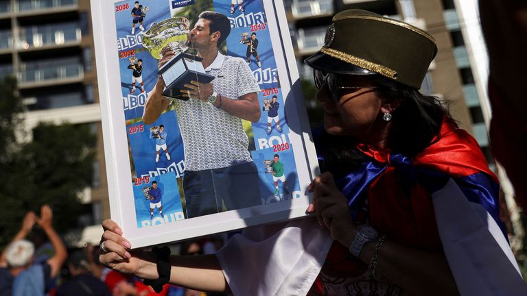 A supporter of Serbian tennis player Novak Djokovic holds his photo during a rally outside the Park Hotel, where the star athlete is believed to be held while he stays in Australia, in Melbourne, Australia, January 9, 2022. REUTERS/Loren Elliott
