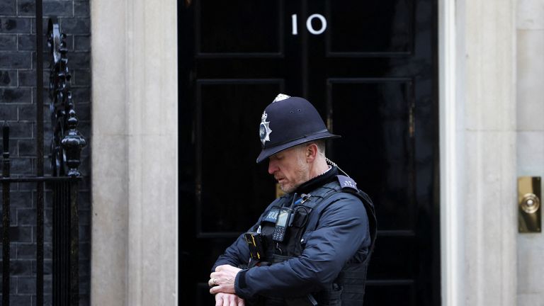 A police officer checks his watch outside Downing Street in London, Britain, January 31, 2022. REUTERS/Henry Nicholls
