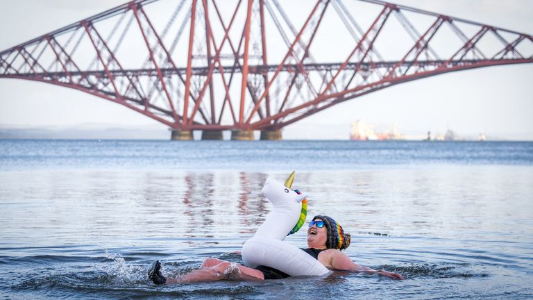 Ashley Park, from Lanark takes part in a New Year&#39;s Day dip in front of the Forth Bridge at South Queensferry, Edinburgh. Covid restrictions across Scotland have meant that many new year traditions including the official annual Loony Dook have been cancelled. Picture date: Saturday January 1, 2022.