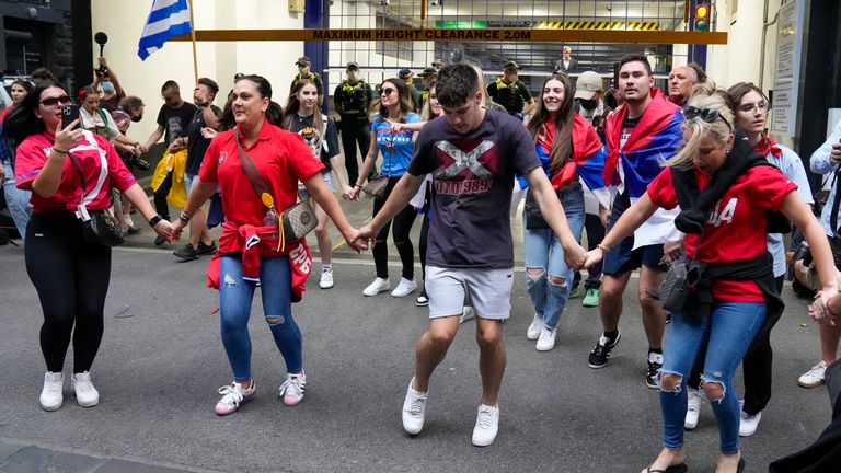 Fans dance and sing outside an immigration detention hotel where Serbian Novak Djokovic is confined in Melbourne, Australia, Monday, Jan. 10, 2022