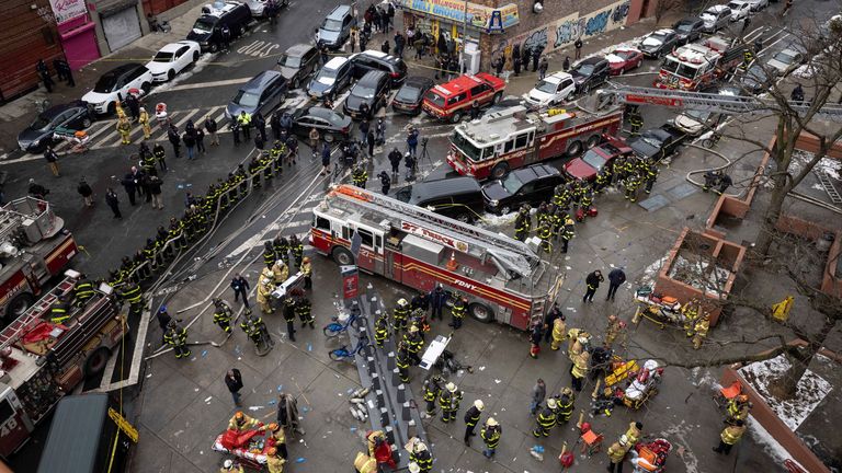 Firefighters work outside an apartment building after a fire in the Bronx, Sunday, Jan. 9, 2022, in New York. (AP Photo/Yuki Iwamura)