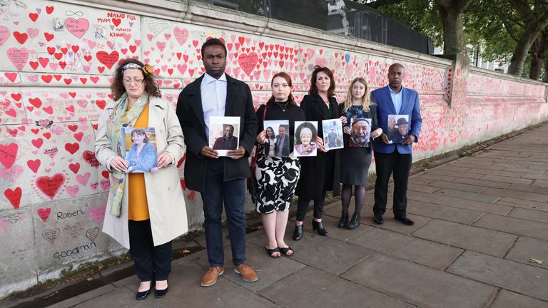 Hannah Brady (third from left) was among bereaved people who held photos of loved ones lost to coronavirus by the COVID memorial wall in London