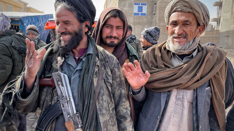 Taliban fighters oversee security at an aid distribution point in Herat