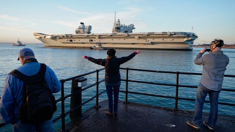 A person waves as the Royal Navy aircraft carrier HMS Prince of Wales leaves Portsmouth Harbour as it sets sail for exercises. For the next year will serve as the Nato command ship, after the Royal Navy took charge of Nato&#39;s fast reaction maritime task force formed to tackle major incidents around the world. Picture date: Wednesday January 12, 2022.
