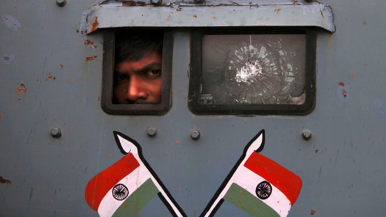An Indian paramilitary soldier peers from the window on armoured vehicle in the disputed Kashmir region