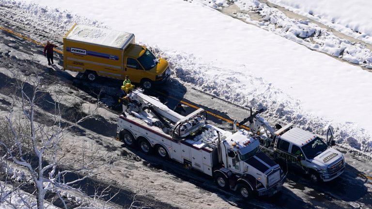 Arbeiter räumen Autos und Lastwagen, die am Dienstag, dem 4. Januar 2022, auf Teilen der Interstate 95 in Carmel Church, Virginia, gestrandet waren, fast 48 Meilen der Autobahn sind wegen Eis und Schnee gesperrt.  (AP Photo/Steve Helber) Bild: AP