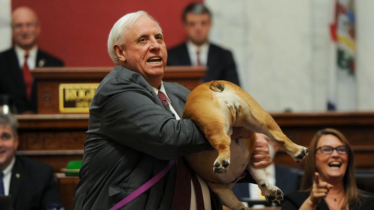 WV Gov. Jim Justice holds up his dog Babydog&#39;s rear end as a message to people who&#39;ve doubted the state as he comes to the end of his State of the State speech in the House chambers Thursday night, Jan. 27, 2022 in Charleston, W.V. (Photo by Chris Dorst/Charleston Gazette-Mail via AP)