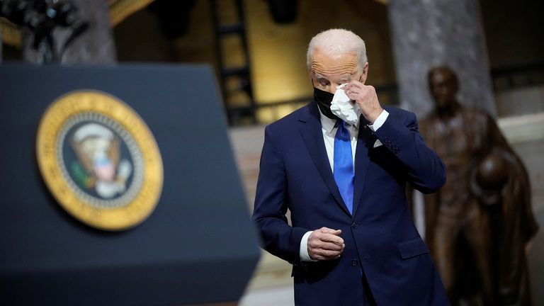 U.S. President Joe Biden wipes his eyes as Vice President Kamala Harris delivers remarks in the Statuary Hall of the U.S. Capitol during a ceremony on the first anniversary of the January 6, 2021 attack on the U.S. Capitol by supporters of former President Donald Trump in Washington, D.C., U.S., January 6, 2022. Drew Angerer/Pool via REUTERS