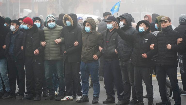 Demonstrators stand in front of police in Almaty