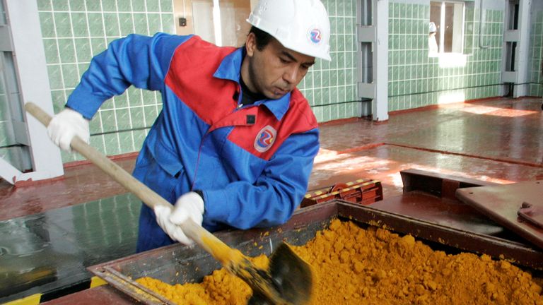FILE PHOTO: A worker rakes uranium oxide after the opening ceremony of the Zarechnoye mine in southern Kazakhstan December 7, 2006.