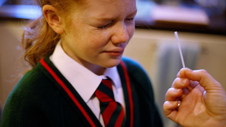 A girl takes a COVID-19 lateral flow self test ahead of returning to school, amid the coronavirus disease (COVID-19) outbreak in Manchester, Britain, January 4, 2022. REUTERS/Phil Noble