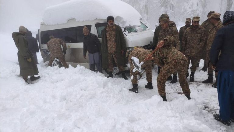 Soldiers clear snow from a road after a heavy snowfall in Murree,