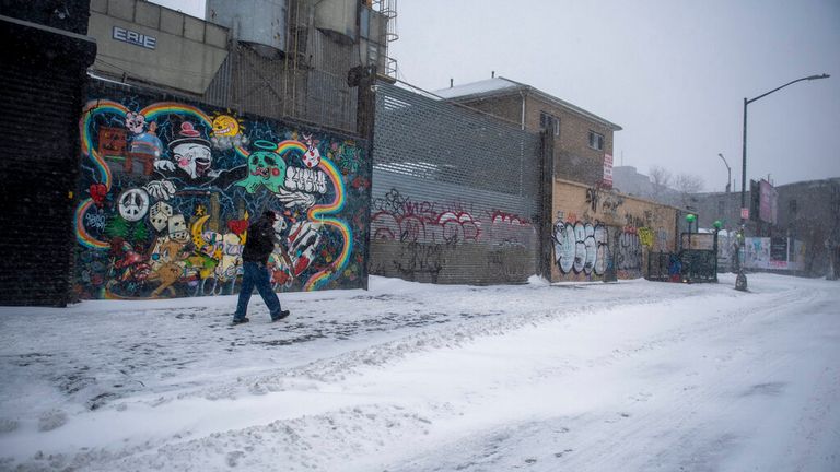 A man walks down the street during a snow storm in Bushwick, Brooklyn on Saturday, Jan. 29, 2022, in New York. (AP Photo/Brittainy Newman) 