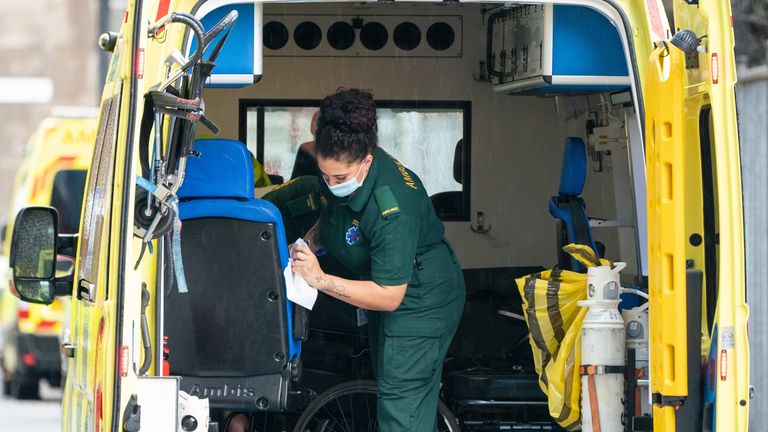 A paramedic cleans the inside of an ambulance outside the Royal London Hospital in London