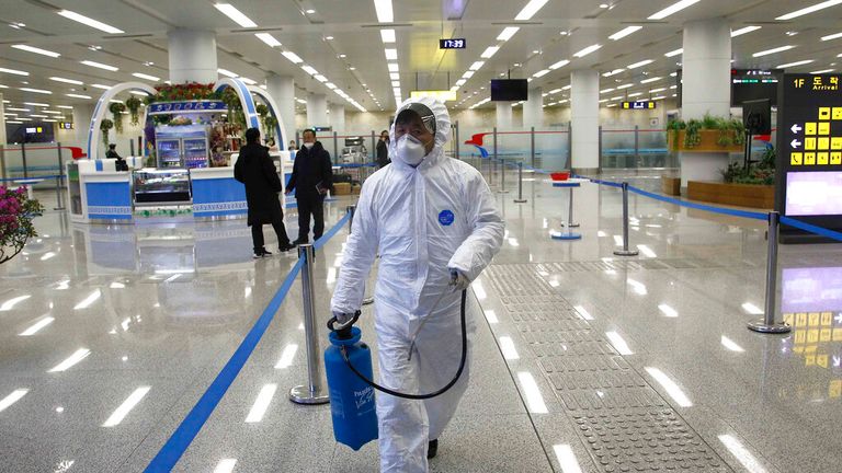 کارکنان فرودگاه پیونگ یانگ با لباس های محافظ در آغاز همه گیری در فوریه 2020 عکس: AP 