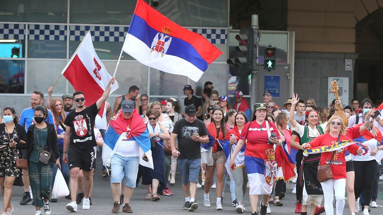 Fans of Serbia&#39;s Novak Djokovic react to news of his court win and march towards Federation Square ahead of the Australian Open in Melbourne, Australia, Monday, Jan. 10, 2022.   (AP Photo/Hamish Blair)