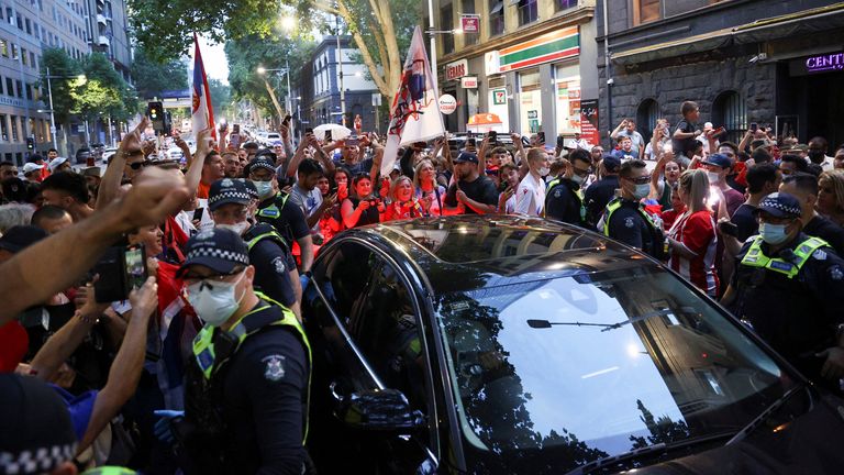 Supporters of Serbian tennis player Novak Djokovic gather around a car outside what is believed to be the location of his lawyer&#39;s office during an ongoing day of legal proceedings over the cancellation of his visa to play in the Australian Open, in Melbourne, Australia, January 10, 2022. REUTERS/Loren Elliott
