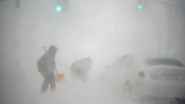 A stranded motorist, at right, gets help shoveling out his car from a passerby with a shovel in Providence, R.I., Saturday, Jan. 29, 2022. A powerful nor&#39;easter swept up the East Coast on Saturday, threatening to bury parts of 10 states under deep, furiously falling snow accompanied by coastal flooding and high winds that could cut power and leave people shivering in the cold weather expected to follow. (AP Photo/David Goldman)