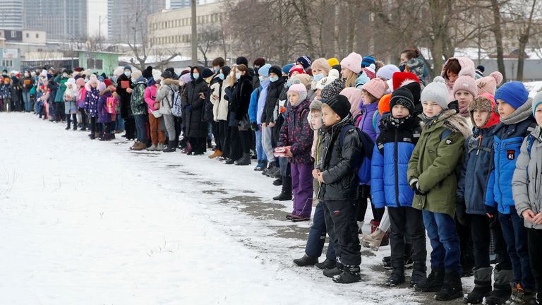 Teachers and schoolchildren line up after an evacuation from the building of a local school during bomb threat and emergency training, which was organized by Ukraine&#39;s State Emergency Service and police, in Kyiv, Ukraine January 27, 2022. REUTERS/Valentyn Ogirenko

