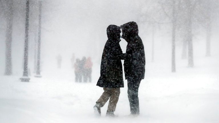 A couple walks through the snow on Boston Common, Saturday, Jan. 29, 2022, in Boston. (AP Photo/Michael Dwyer)