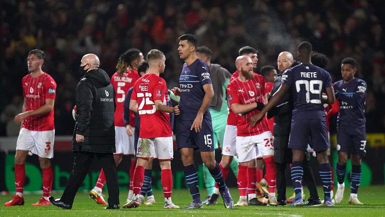 Swindon Town and Manchester City players shake hands after the Emirates FA Cup third round match at the Energy Check County Ground, Swindon. Picture date: Friday January 7, 2022.