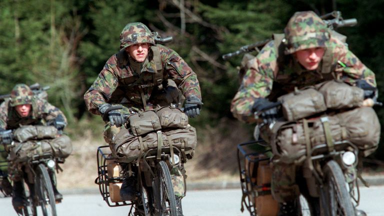 Swiss army soldiers ride their bikes during a military exercise near Moudon in this 1997 file photo. Swiss voters threw out on November 26, 2000 by a sweeping 62.3 percent majority a proposal to slash the budget of the army which is famous for not fighting. The proposed changes called for a cut of one-third from the military's annual 3 billion US dollar budget. The citizen proposal called for any savings from the initiative to be spent on civilian needs. MR/CLH/
