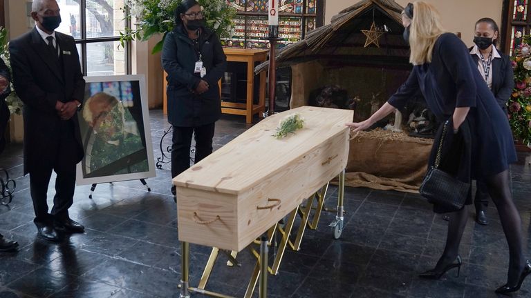 A mourner touches the coffin of Anglican Archbishop Emeritus Desmond Tutu during his funeral at the St. George...s Cathedral in Cape Town, South Africa, Saturday, Jan. 1, 2022. Tutu, the Nobel Peace Prize-winning activist for racial equality and LGBT rights died Sunday at the age of 90. (Nic Bothma/Pool via AP)       